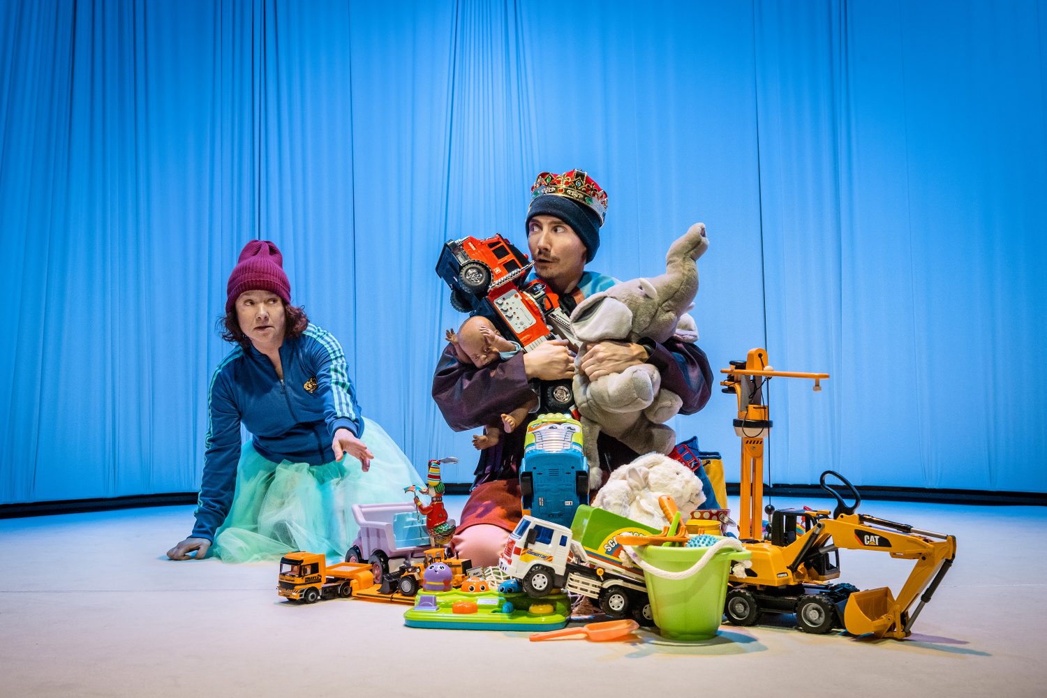 Pjäsen Den lille girige. Två personer på golvet och massor av leksaker.