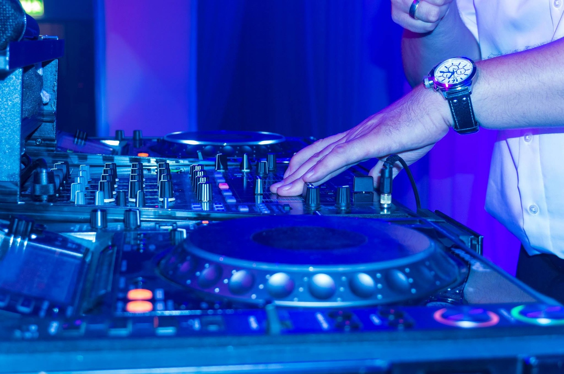DJ-utrustning och en hand som mixar musik. Cred Philipp Ruch, Pixabay.